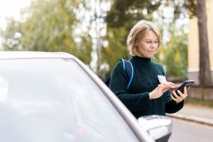 Mesimarjan työntekijä puhelin kädessä auton vieressä.